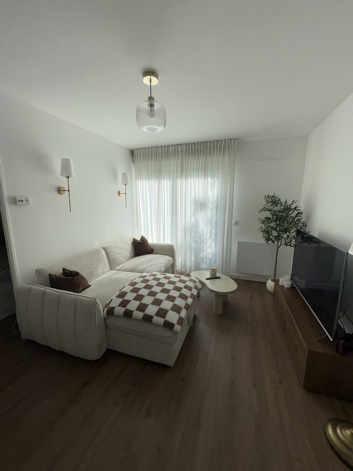 Séjour clair avec appliques dorées et parquet foncé