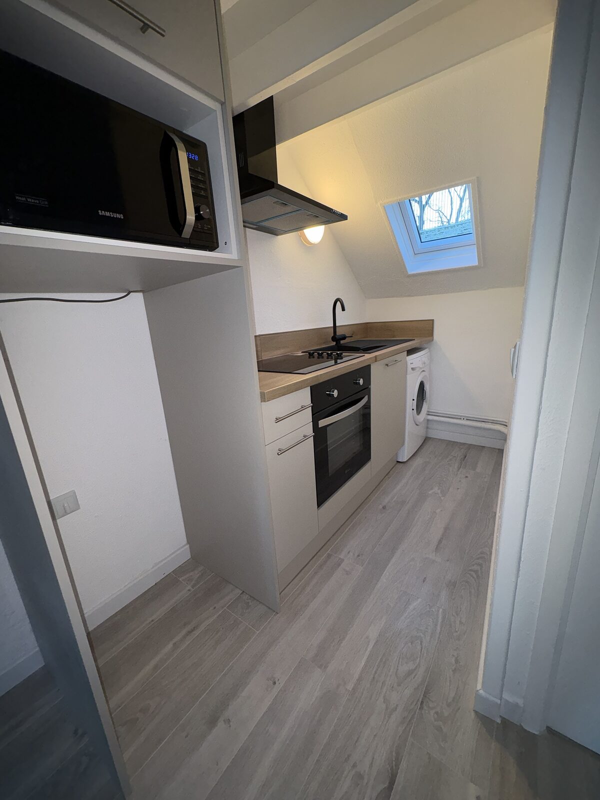 Cuisine sous rampant avec velux et plan de travail bois